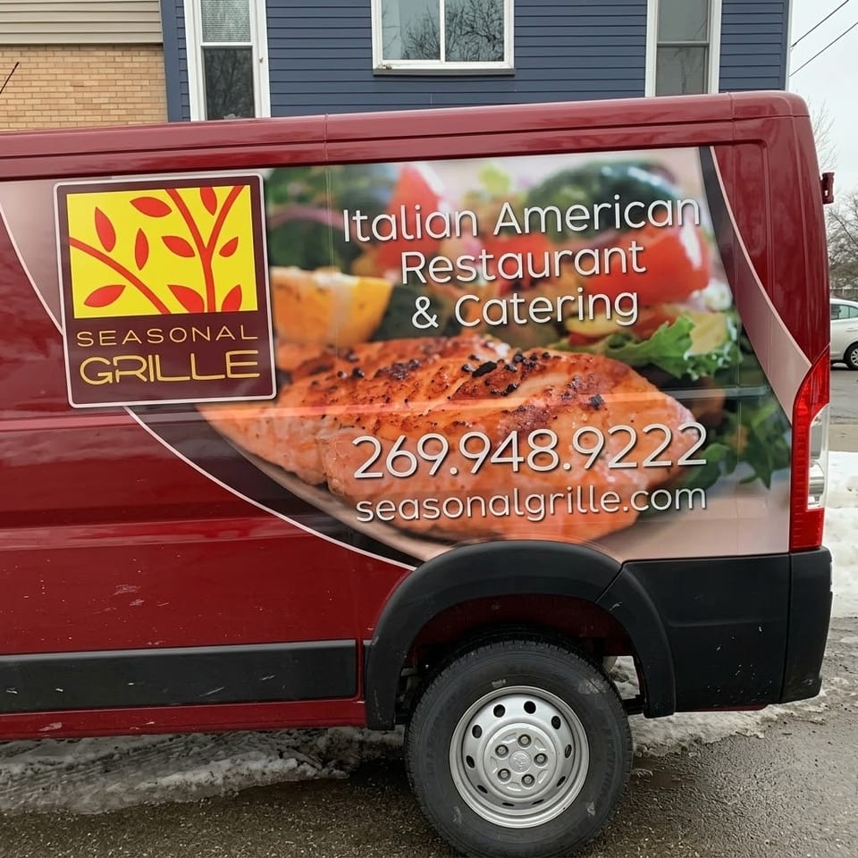 Seasonal Grille Italian American restaurant and catering van displaying grilled salmon and salad imagery outside in snowy weather.